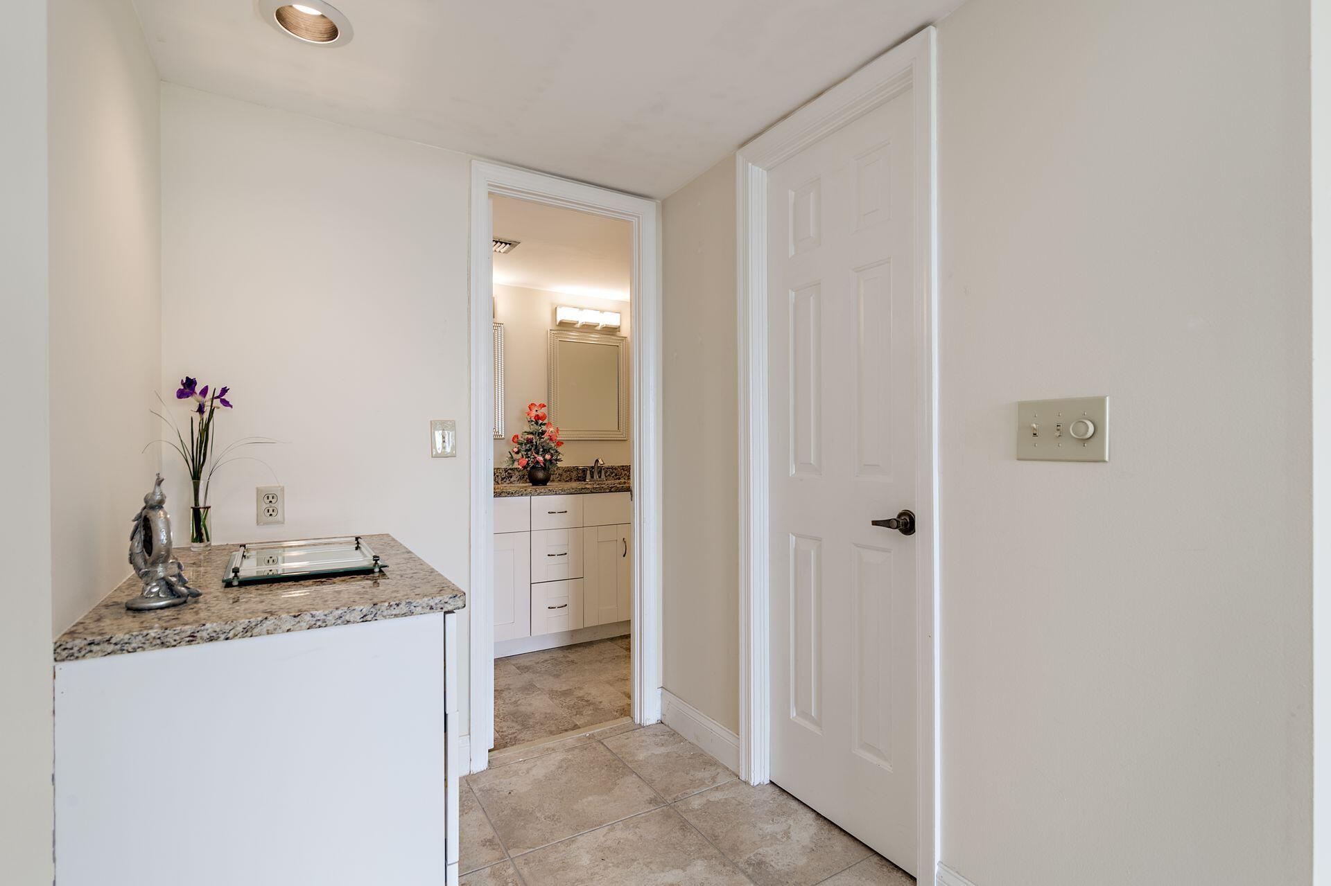 356 Golfview Road, Unit 204 North Palm Beach, FL 33408 - Photo 13 of 71 a bathroom with a granite countertop sink and white cabinets