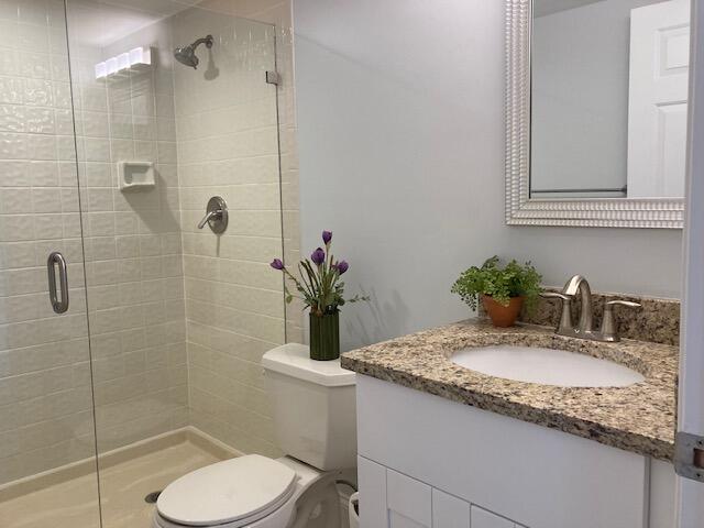 356 Golfview Road, Unit 204 North Palm Beach, FL 33408 - Photo 15 of 71 a bathroom with a granite countertop sink toilet and shower