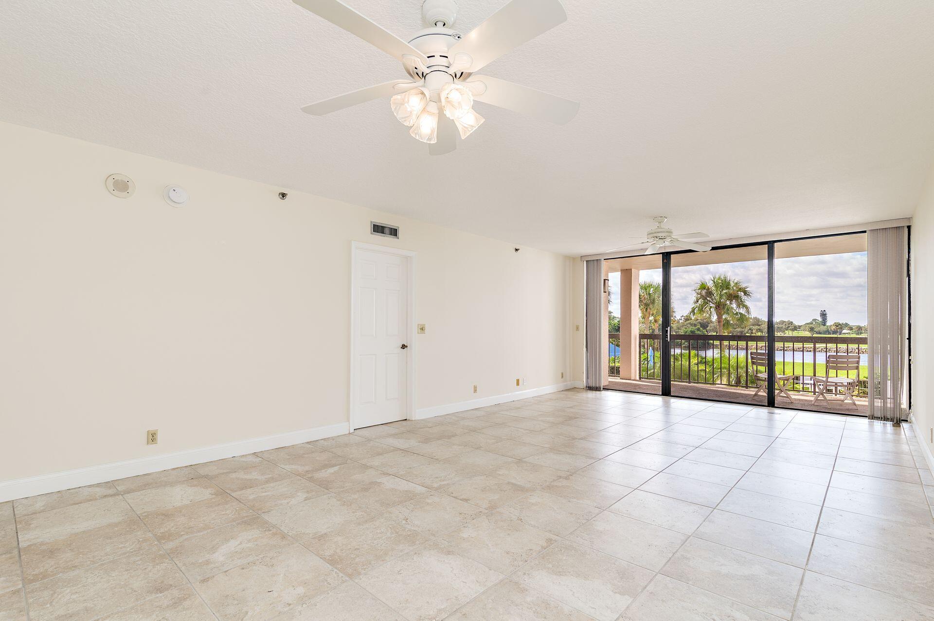 356 Golfview Road, Unit 204 North Palm Beach, FL 33408 - Photo 16 of 71 an empty room with chandelier fan and windows