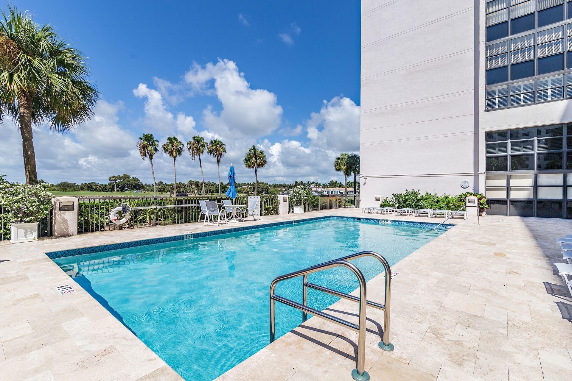 356 Golfview Road, Unit 204 North Palm Beach, FL 33408 - Photo 30 of 71 a view of a swimming pool with a lounge chair and palm trees