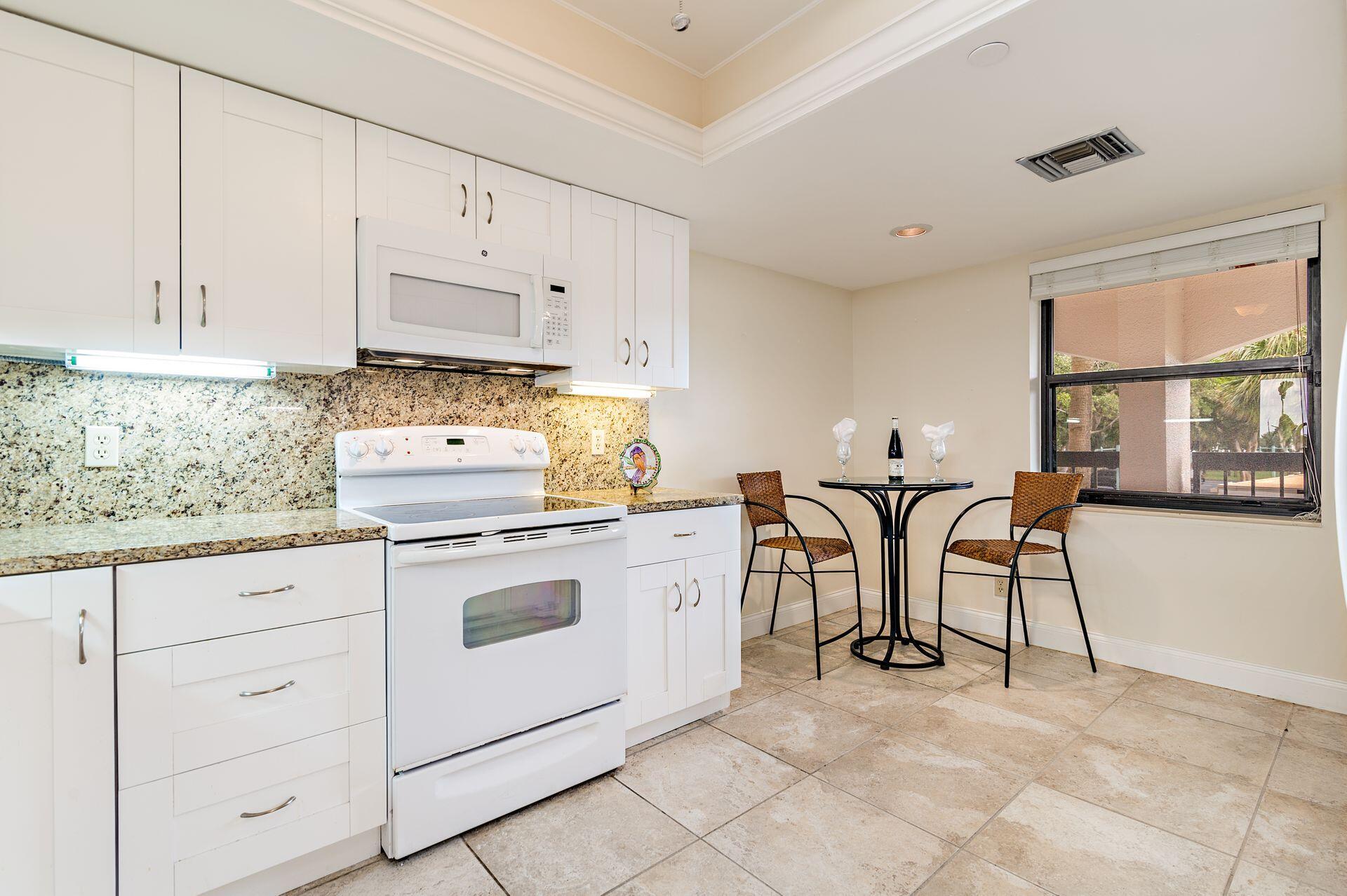 356 Golfview Road, Unit 204 North Palm Beach, FL 33408 - Photo 6 of 71 a kitchen with cabinets and chairs