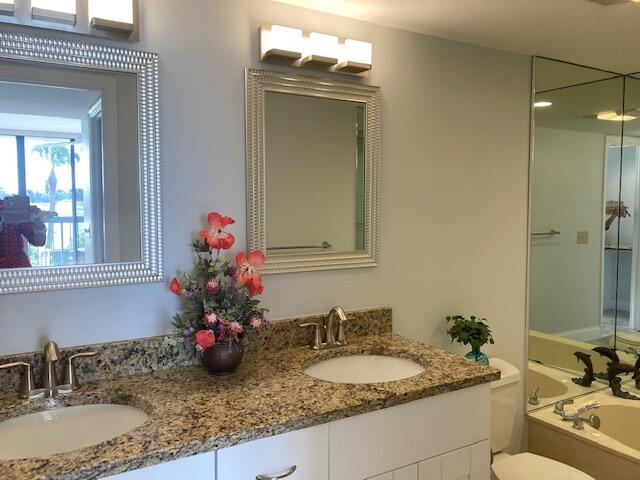 356 Golfview Road, Unit 204 North Palm Beach, FL 33408 - Photo 64 of 71 a bathroom with a granite countertop sink a large mirror and a window