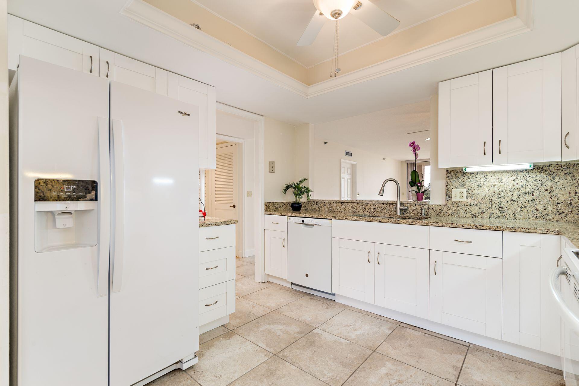356 Golfview Road, Unit 204 North Palm Beach, FL 33408 - Photo 9 of 71 a kitchen with white cabinets and refrigerator