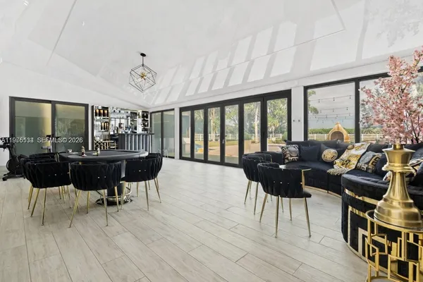 a living room with furniture a large window and wooden floor