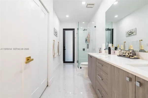 a bathroom with a sink a toilet and shower