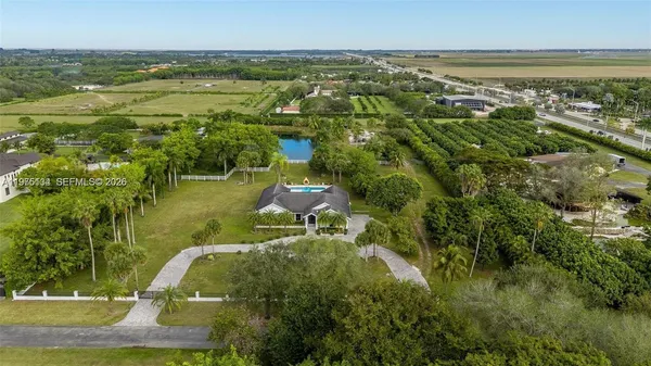 an aerial view of residential houses with outdoor space and trees