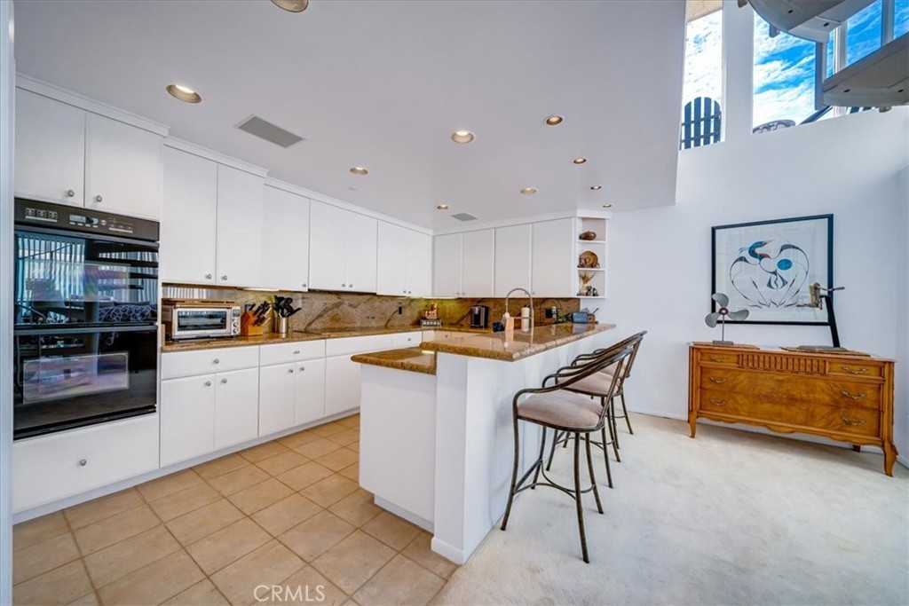 555 Esplanade, Unit 518 Redondo Beach, CA 90277 - Photo 22 of 73 a kitchen with stainless steel appliances granite countertop a refrigerator and a stove top oven
