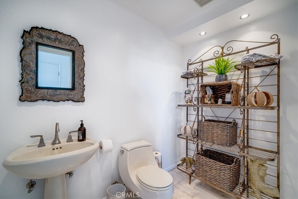 555 Esplanade, Unit 518 Redondo Beach, CA 90277 - Photo 27 of 73 a bathroom with a toilet sink and mirror