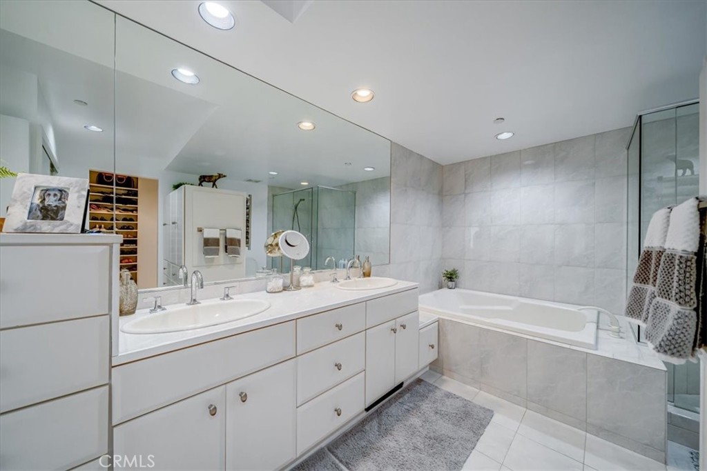 555 Esplanade, Unit 518 Redondo Beach, CA 90277 - Photo 41 of 73 a bathroom with a double vanity sink a mirror and a bathtub