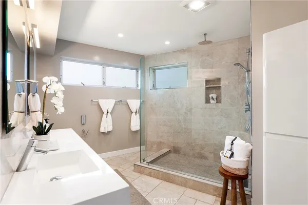 a bedroom with a bed a mirror and a potted plant