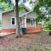 a view of a house with a yard and large tree