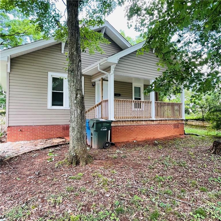 a view of a house with a yard and large tree
