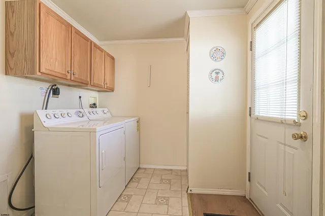 a utility room with a sink a cabinetry and a window