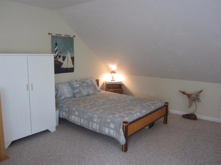 10 Captain Kidd Road East Sandwich, MA 02537 - Photo 20 of 31 a spacious bedroom with a bed and a chandelier