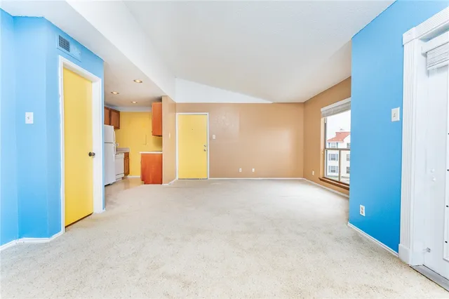 a view of an empty room with window and bathroom