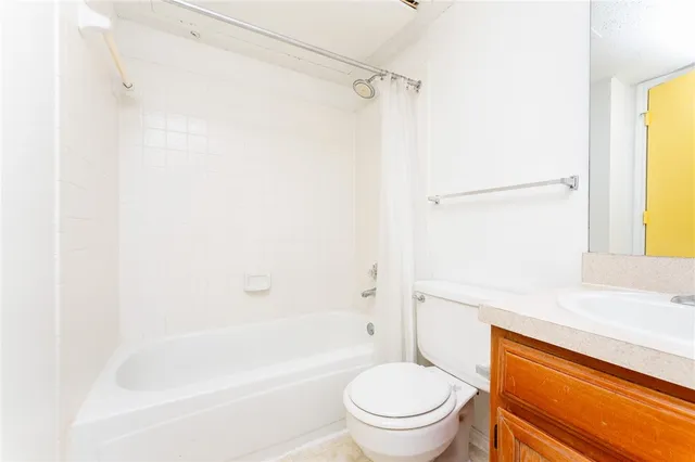 a bathroom with a bathtub shower sink vanity and toilet
