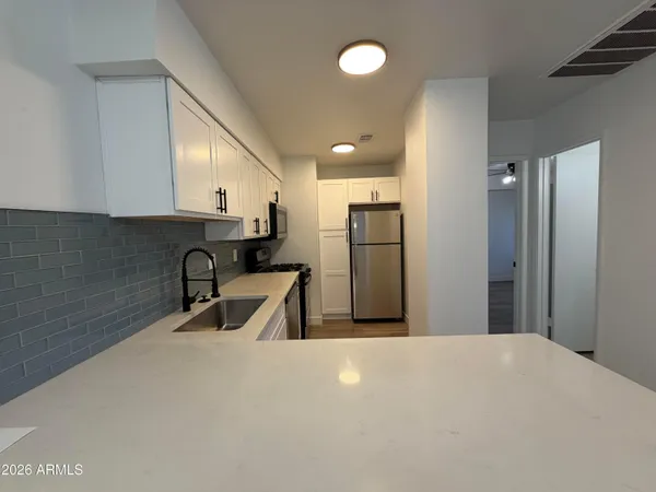 a kitchen with a refrigerator a sink and a cabinets