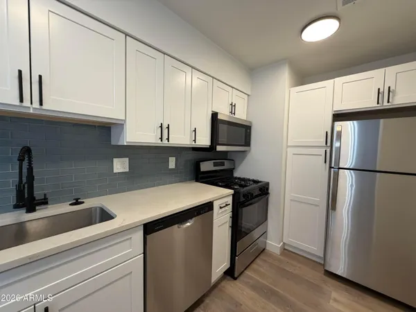 a kitchen with a refrigerator sink and cabinets