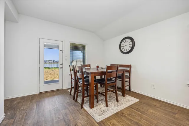 a view of a dining room and livingroom with furniture wooden floor and a rug