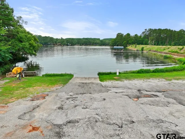 a backyard of a house with chairs and large trees