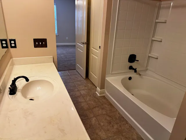 a bathroom with a tub sink and mirror