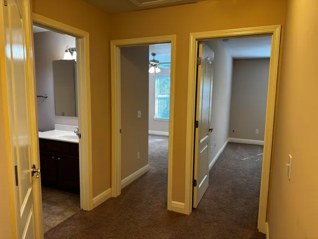 a view of a bathroom from a hallway and natural light
