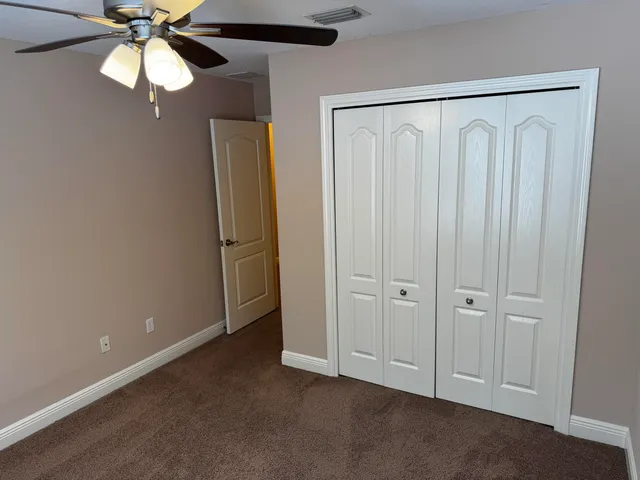 a view of an empty room with a chandelier fan