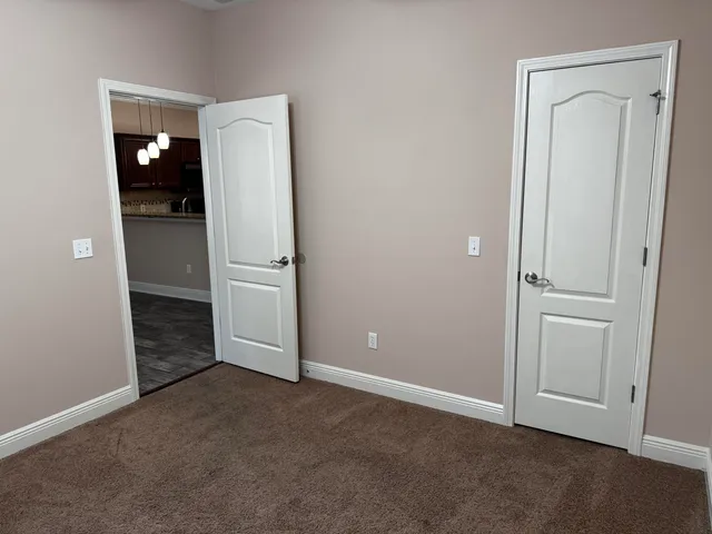 an empty room with closet and mirror