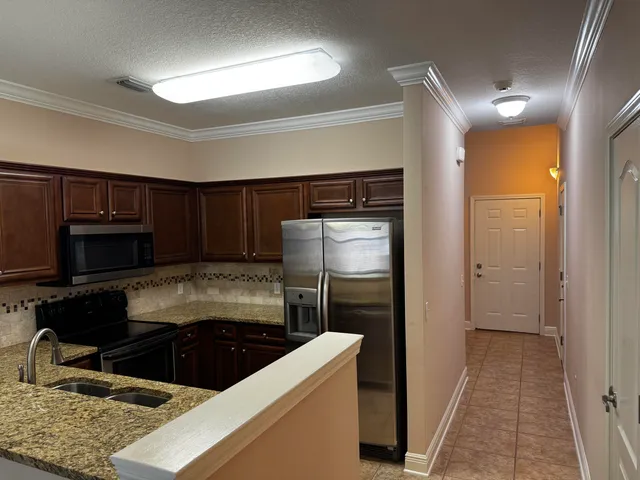 a kitchen with a refrigerator and a stove top oven