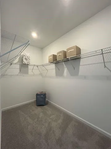 a white toilet sitting next to a white wall