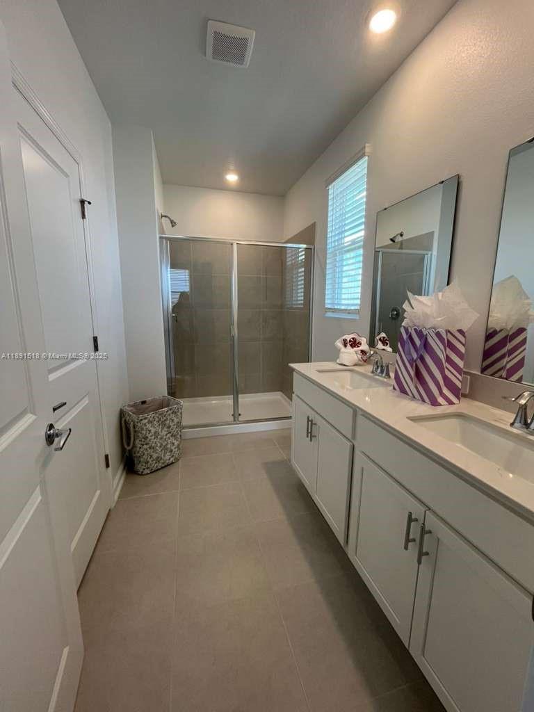 5984 Zen Way, Unit 5984 Clermont, FL 34714 - Photo 22 of 51 a bathroom with a double vanity sink and mirror with shower