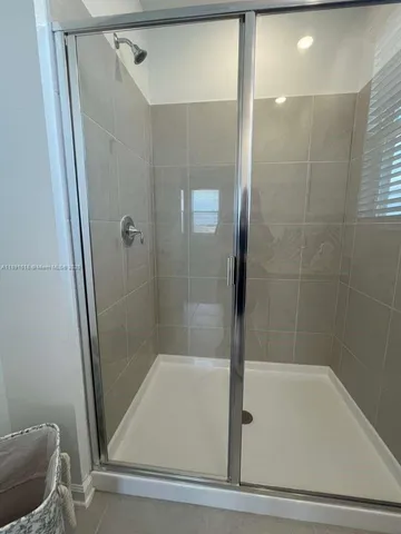 a spacious bathroom with a double vanity sink a mirror and shower
