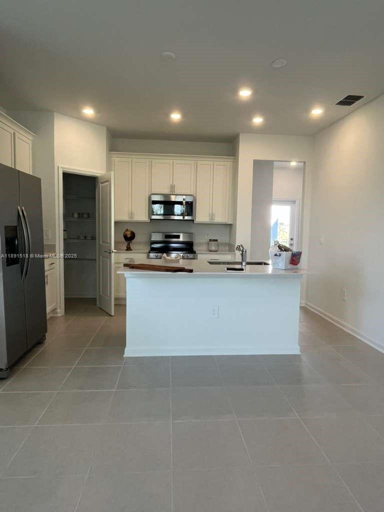 5984 Zen Way, Unit 5984 Clermont, FL 34714 - Photo 38 of 51 a large kitchen with stainless steel appliances a refrigerator stove a sink and a microwave