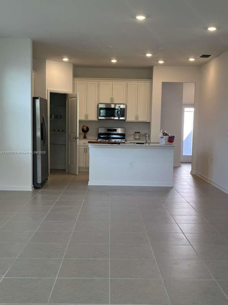 5984 Zen Way, Unit 5984 Clermont, FL 34714 - Photo 39 of 51 a living room with stainless steel appliances kitchen island granite countertop a sink and cabinets