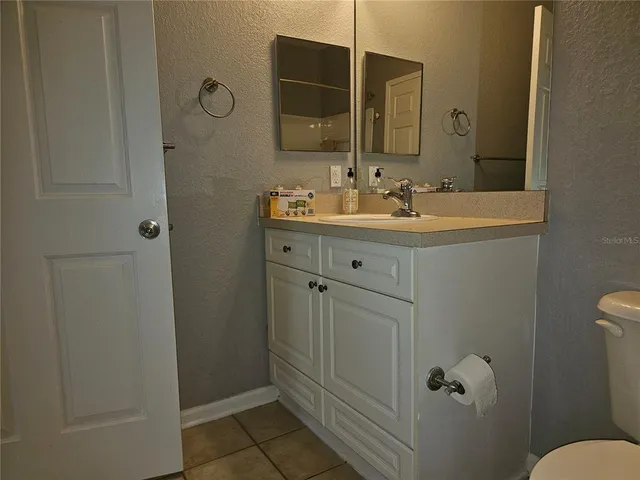a bathroom with a sink mirror vanity and toilet