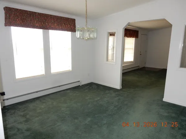 an empty room with windows and fireplace