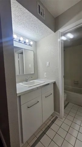 a spacious bathroom with a mirror sink and toilet