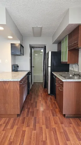 a large kitchen with stainless steel appliances granite countertop a stove a sink and a refrigerator