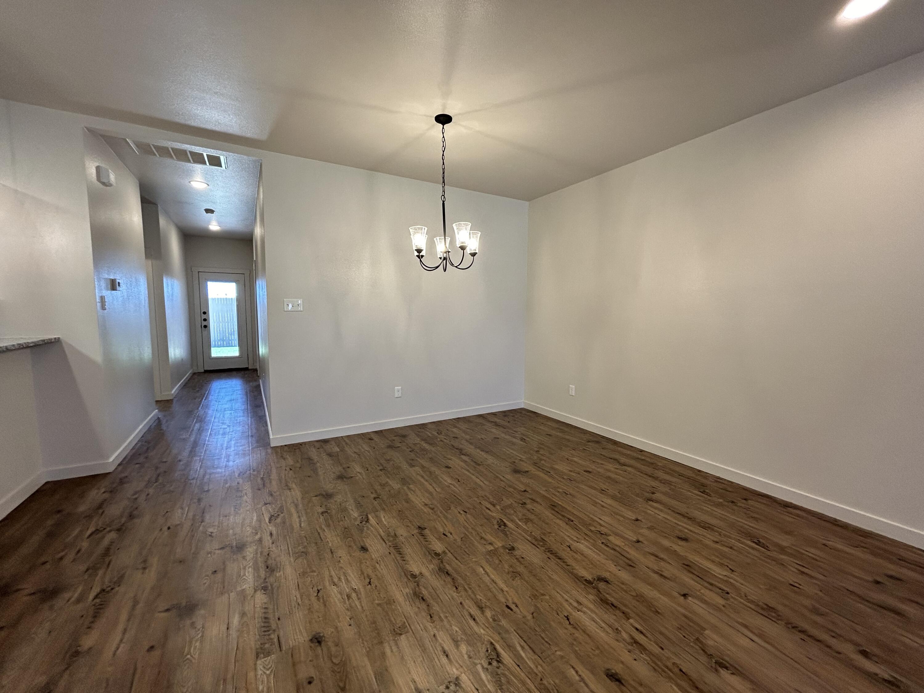 2547 138th Street Lubbock, TX 79423 - Photo 3 of 11 a view of a room with wooden floor and chandelier