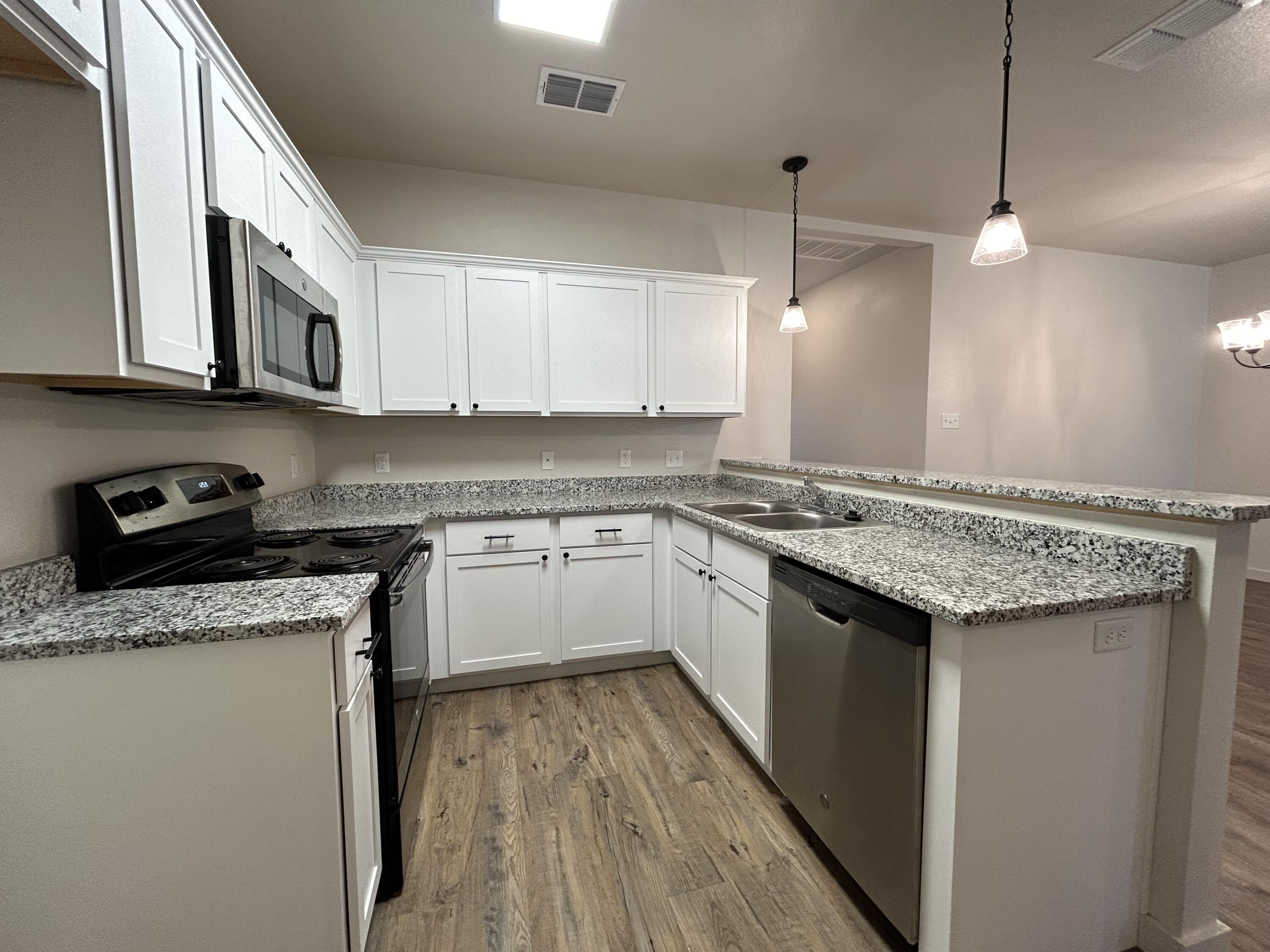 2547 138th Street Lubbock, TX 79423 - Photo 4 of 11 a kitchen with granite countertop cabinets stainless steel appliances and a sink