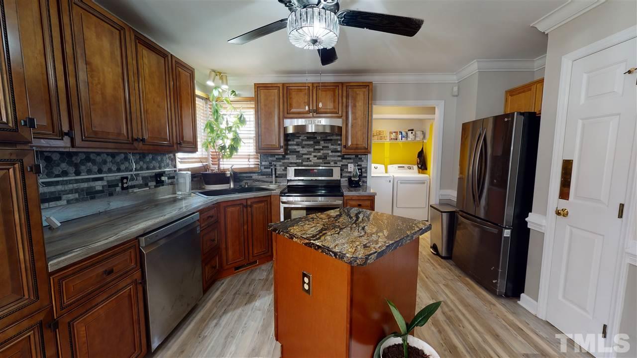 4232 Birmingham Way Raleigh, NC 27604 - Photo 11 of 30 a kitchen with a refrigerator a sink dishwasher a stove and a refrigerator with wooden floor