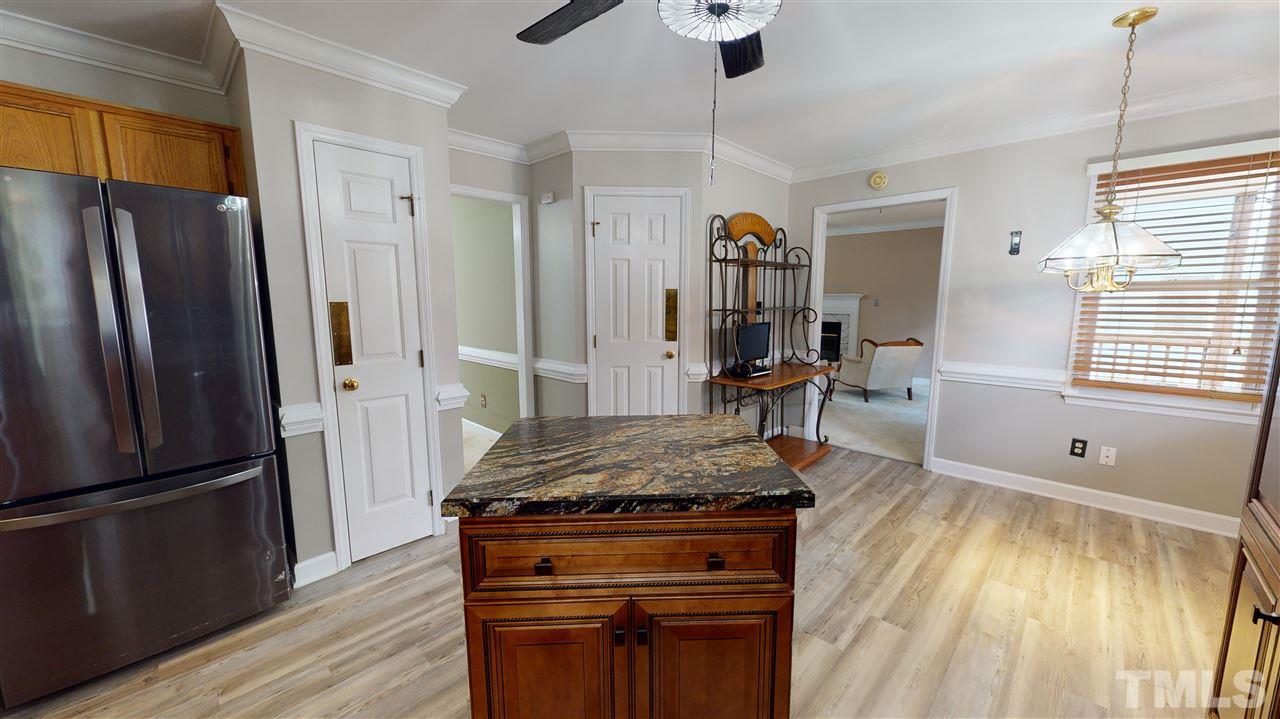 4232 Birmingham Way Raleigh, NC 27604 - Photo 13 of 30 a kitchen with granite countertop a refrigerator stove and wooden floor