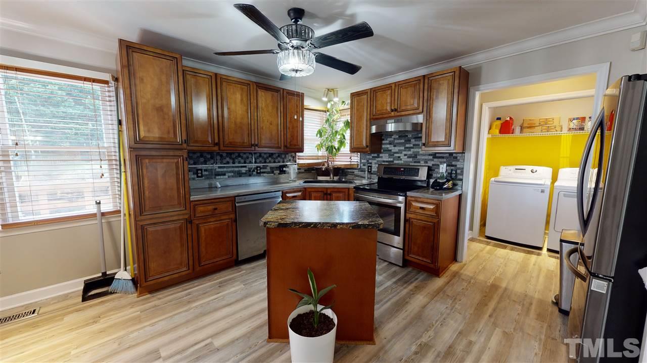 4232 Birmingham Way Raleigh, NC 27604 - Photo 10 of 30 a kitchen with stainless steel appliances granite countertop a refrigerator a stove a sink dishwasher and wooden cabinets with wooden floor