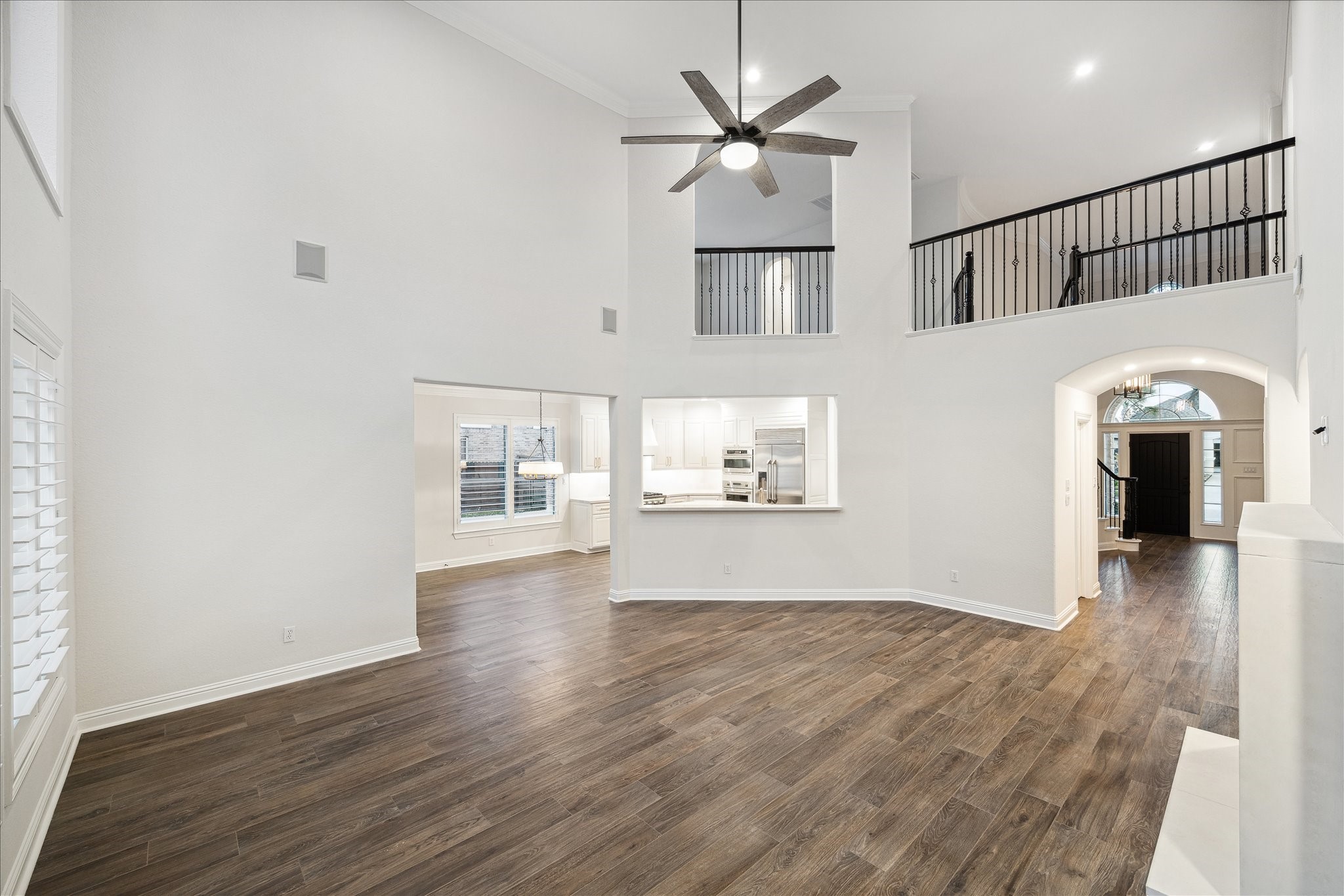 6211 Alameda Point Lane Houston, TX 77041 - Photo 26 of 50 Sweeping view from the family room into the grand entry showcasing the open-concept flow, soaring two-story ceilings, and elegant curved staircase. A seamless and impressive connection between the heart of the home and its entry.