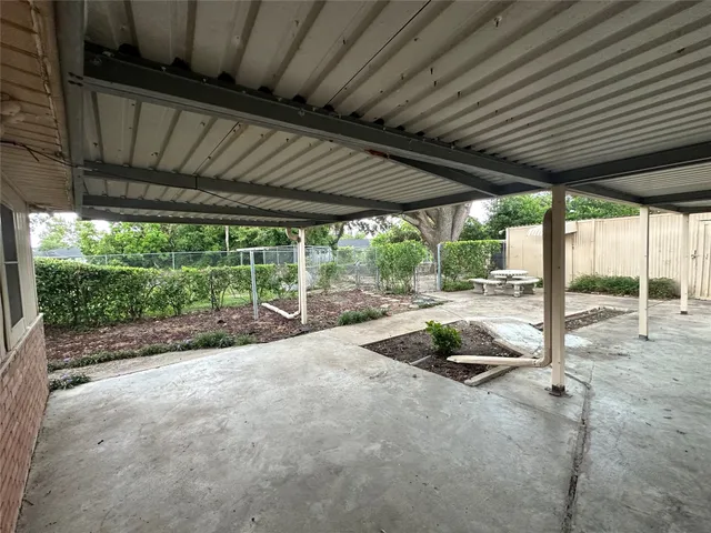 a view of a backyard with floor to ceiling window and wooden fence