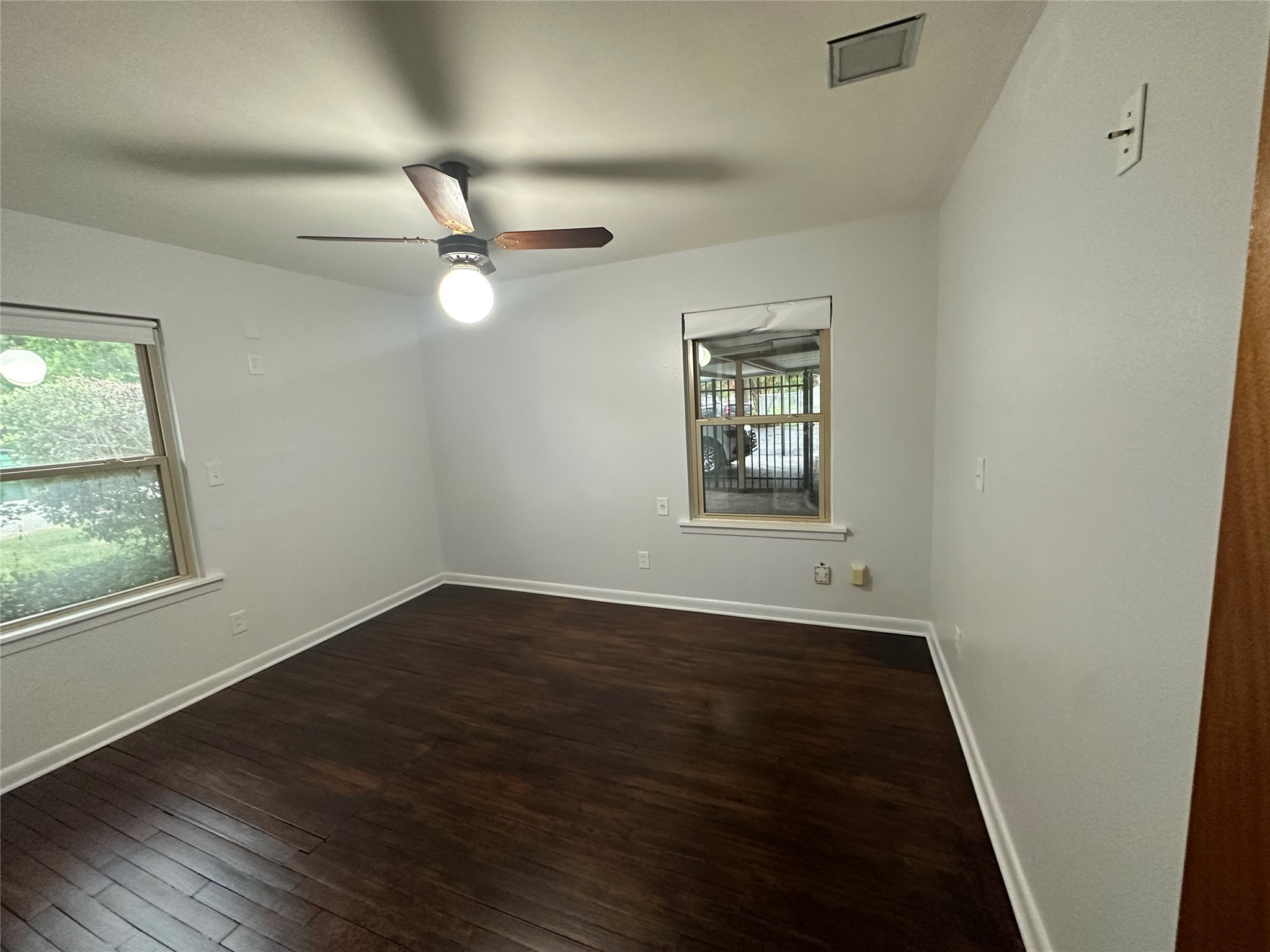 4101 Philco Drive Houston, TX 77080 - Photo 7 of 23 an empty room with wooden floor ceiling fan and windows