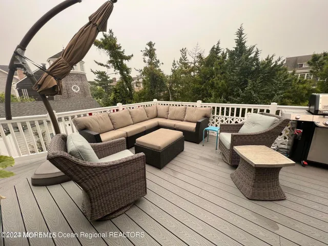 a balcony with wooden floor and outdoor seating