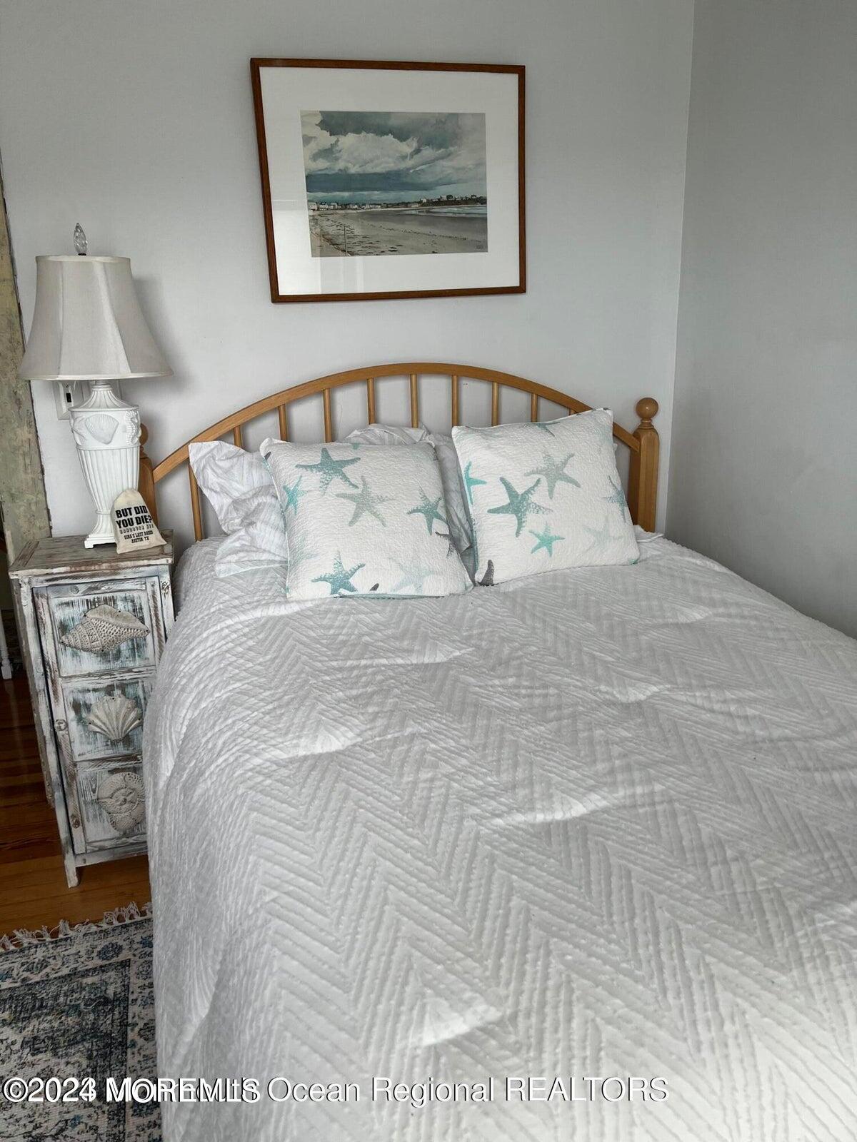 106 Mathis Place, Unit PO243 Mantoloking, NJ 08738 - Photo 21 of 25 a large bed sitting in a bedroom next to a lamp