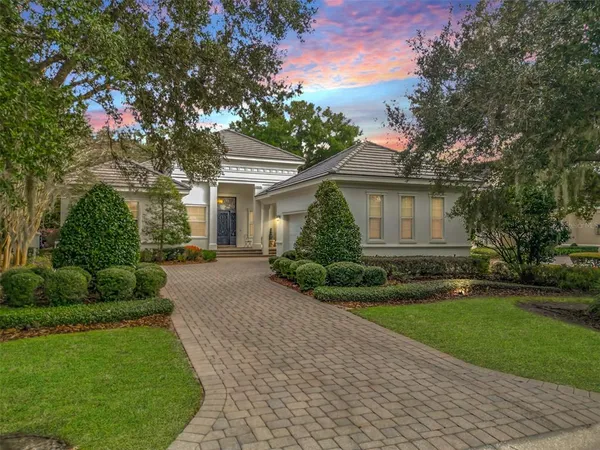 a front view of a house with a garden and yard