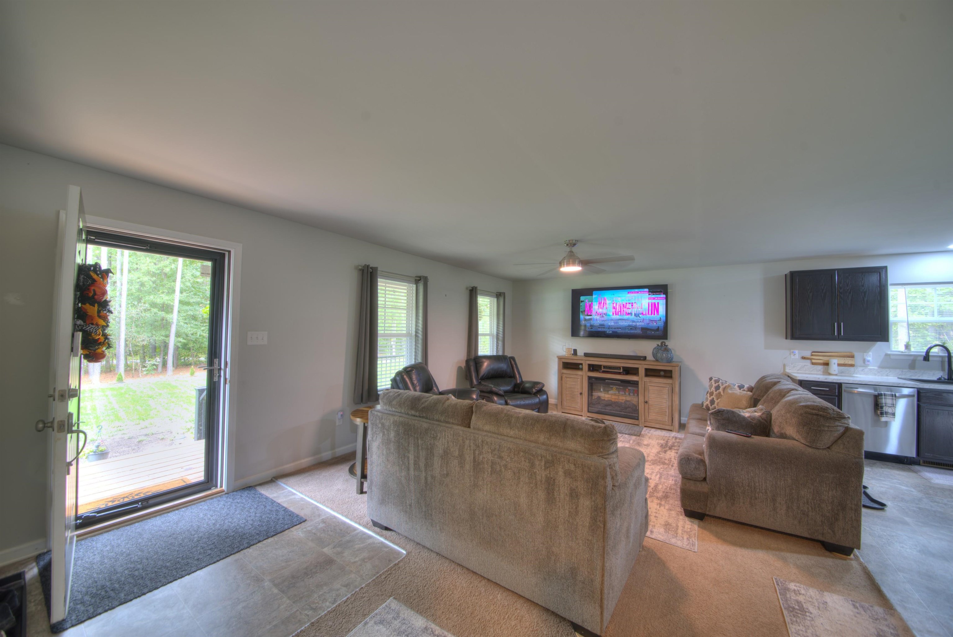 2635 Bumpass Road Bumpass, VA 23024 - Photo 22 of 38 a living room with furniture a flat screen tv and a large window